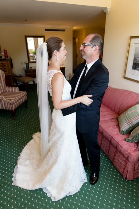 Brides father looking at her daughter getting ready for the wedding