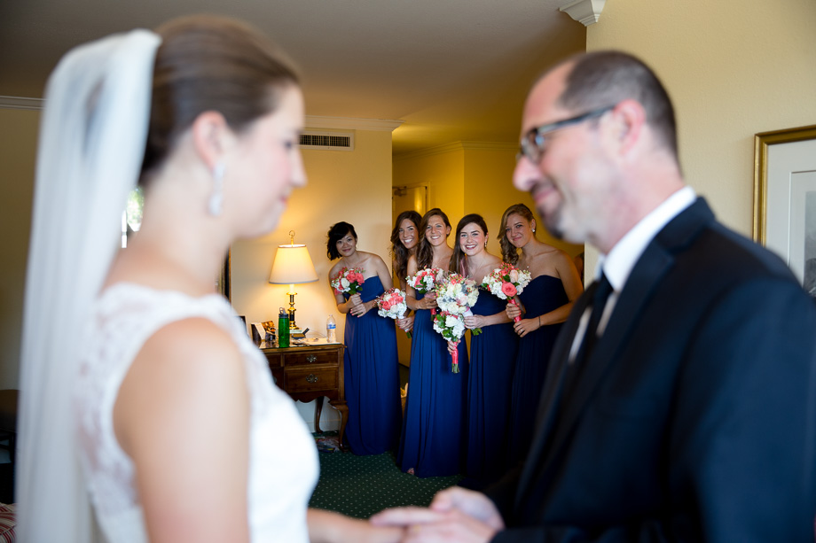 Bridesmaids peeking at the bride and her father