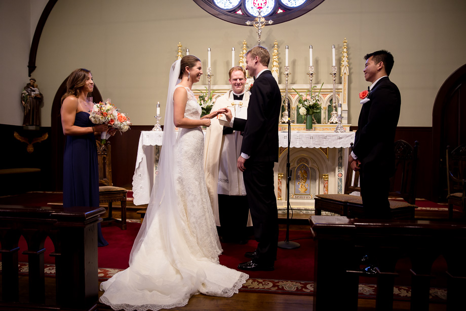 Officiant speaking with the bride and groom on either side during wedding ceremony at Church of the Nativity