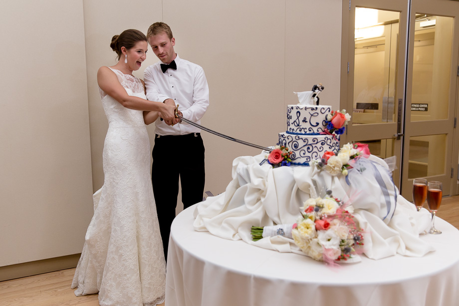 Bride and groom cutting wedding cake with a long sword at Ladera Oaks