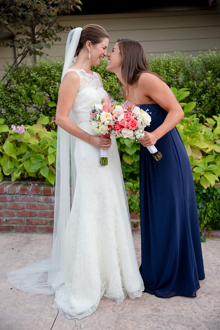 Bride looking at her sister the maid of honor making funny faces
