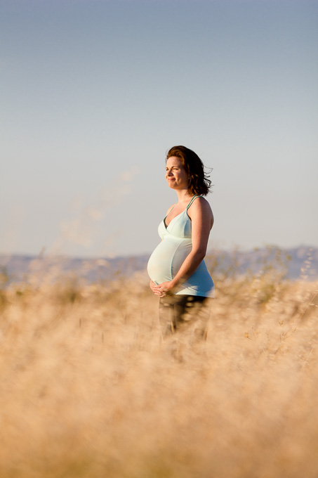 Expectant mother in grassy field - maternity photo shoot
