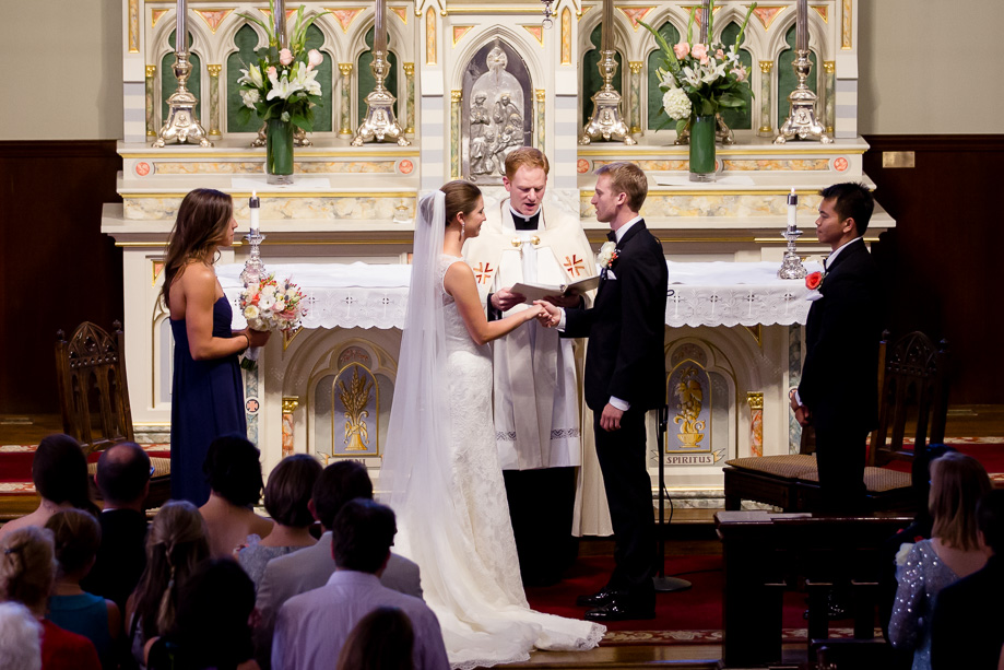 Officiant speaking with the bride and groom on either side during wedding ceremony at Church of the Nativity