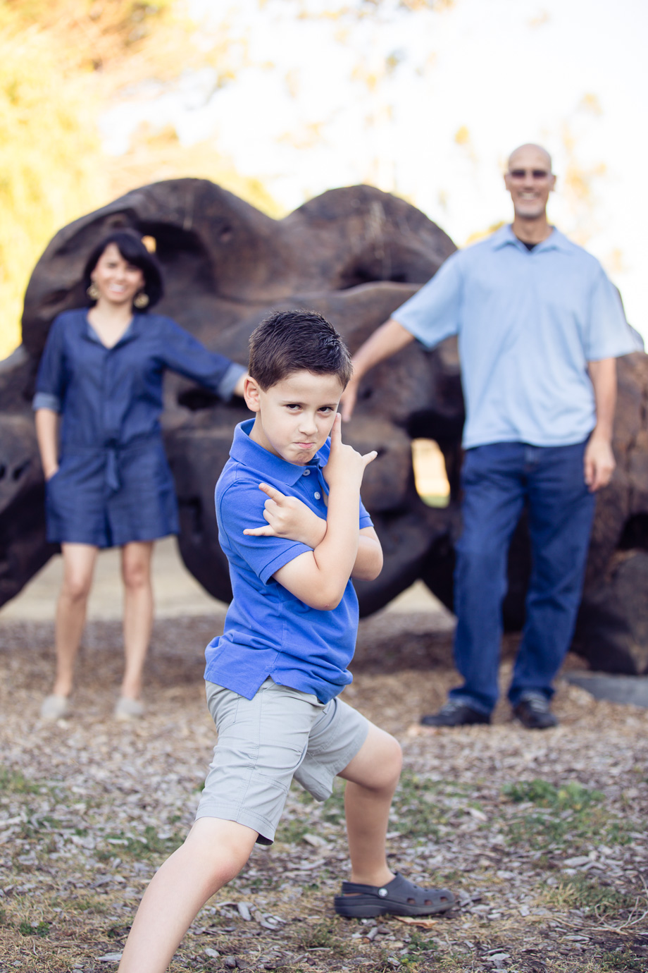young boy making cool Spiderman pose in front of his parents