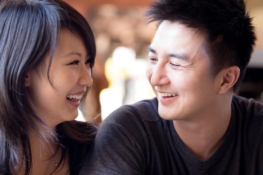 casual photo of the couple looking at each other playfully smiling and laughing