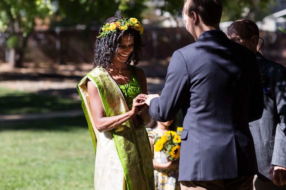 Bride putting wedding band on grooms finger