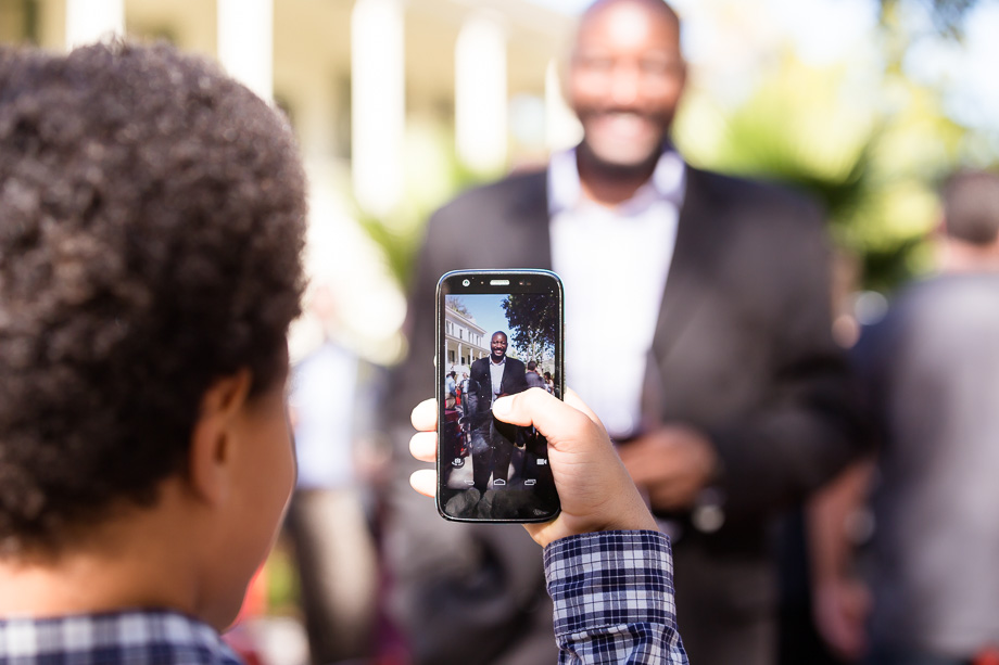 Son taking a phone pic of his father