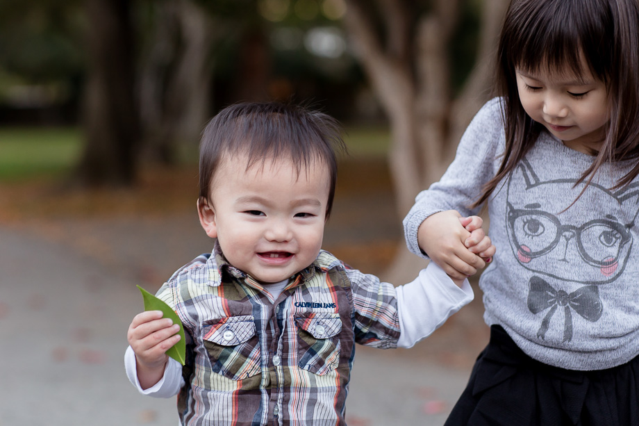 Cute caring big sister walking little brother
