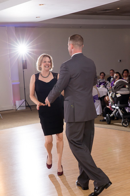 Happy groom and mother dance during wedding reception