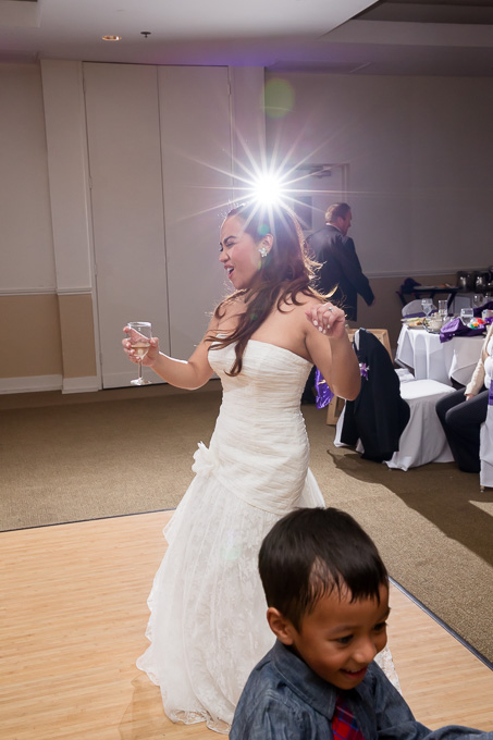 The bride having fun on the dance floor holding a glass of champagne