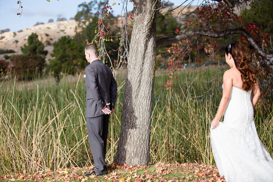 bride approaching the groom under a tree for the first look