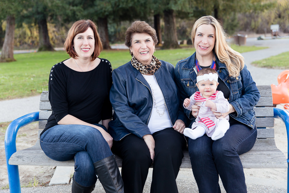 Three-generation family portrait on a bench at Vasona park kids playground