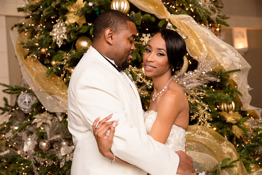 bride and groom in front of a Christmas tree