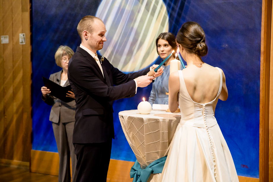 couple lighting the unity candle at the ceremony