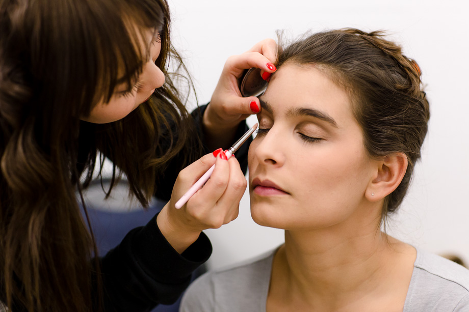 Bridesmaids helping each other with makeup at a CuriOdyssy wedding