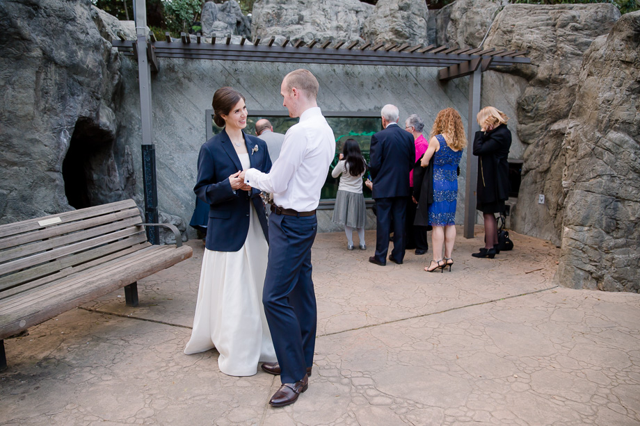 newlywed sharing a moment while guests visiting the animals at CuriOdyssey museum