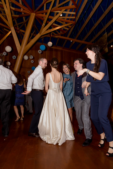 guests circling around the newlyweds at their wedding reception