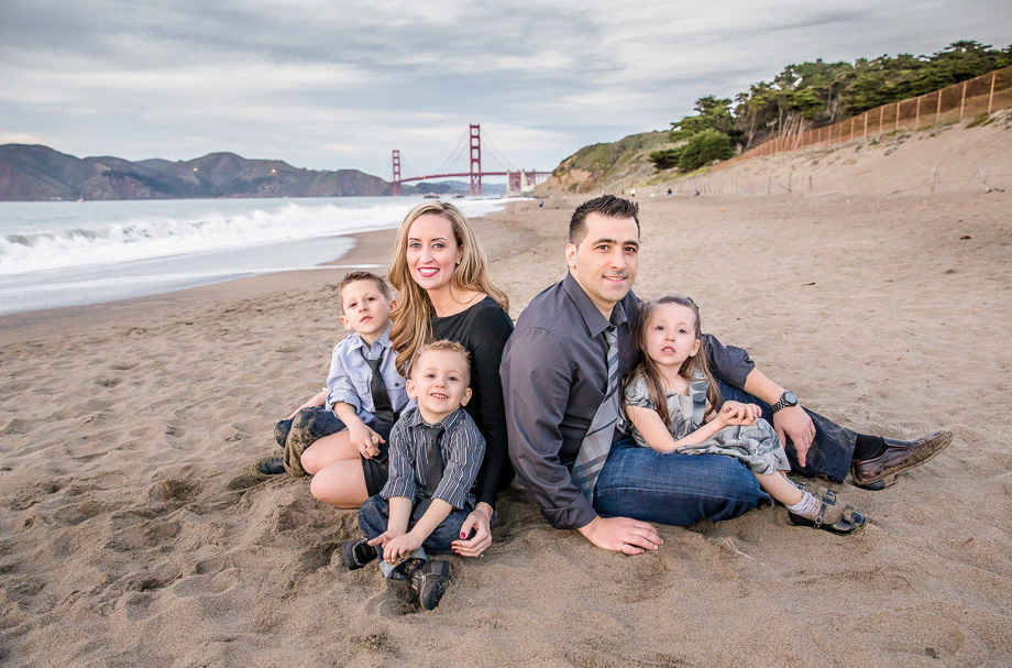 dramatic family photo in front of golden gate bridge at baker beach