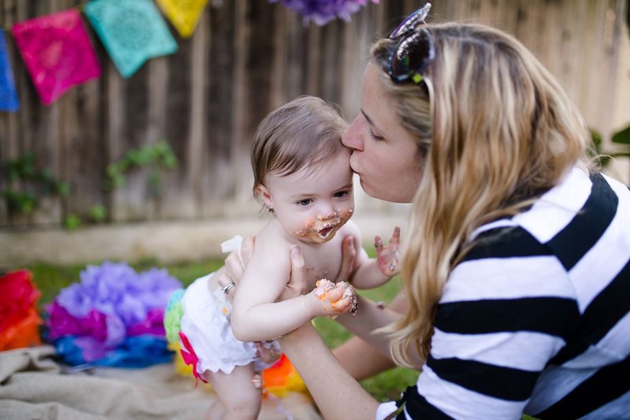mommy kisses her girl after the cake smash