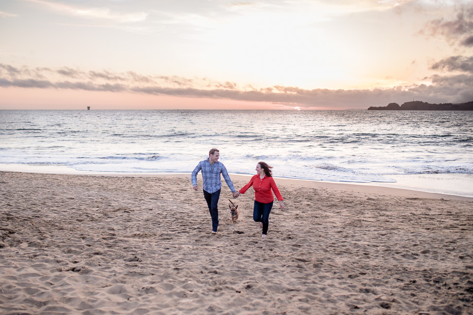 running shot of the engaged couple and their dog