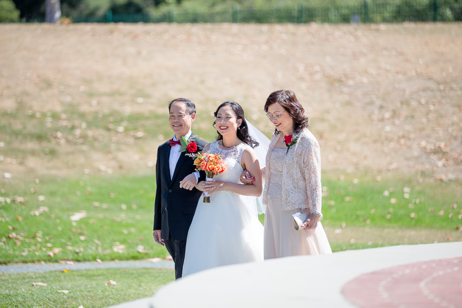 bride escorted by her parents down the aisle