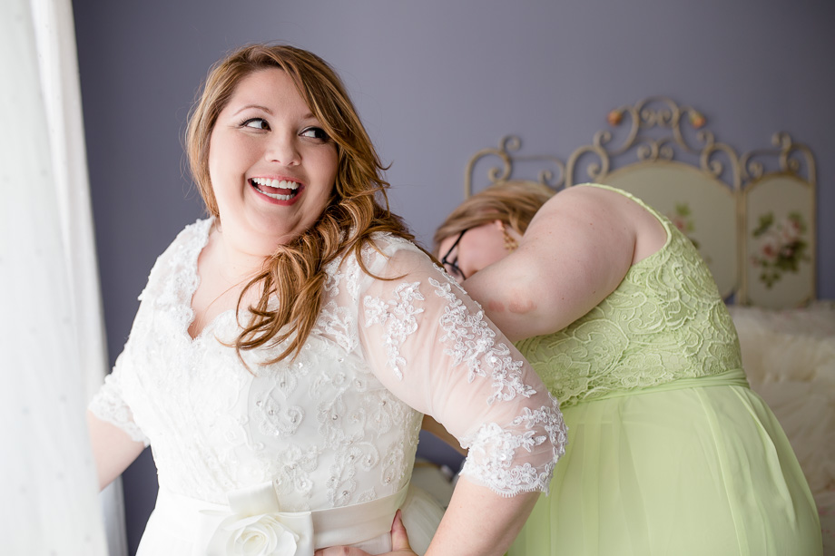 bridesmaid fixing wedding dress