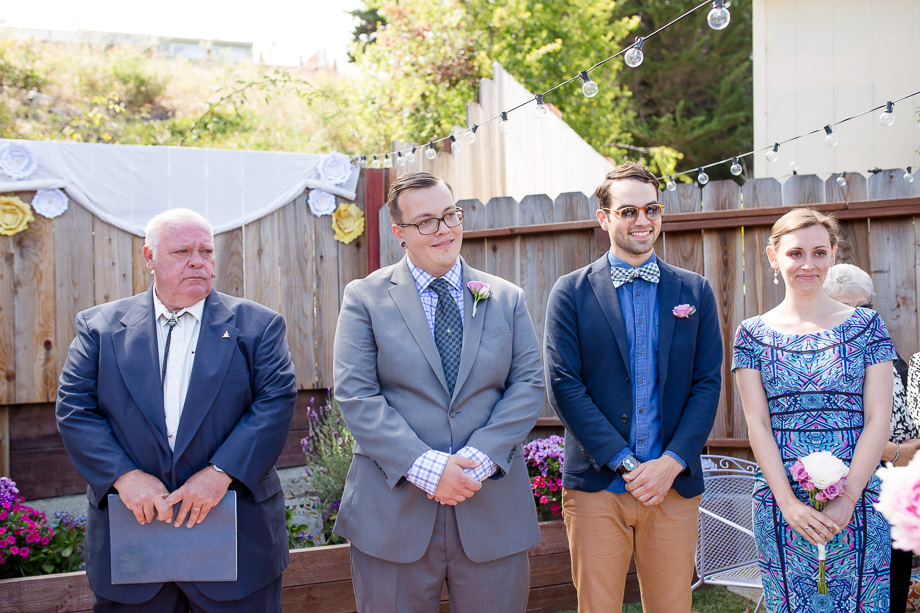 groom watching bride walking down the aisle