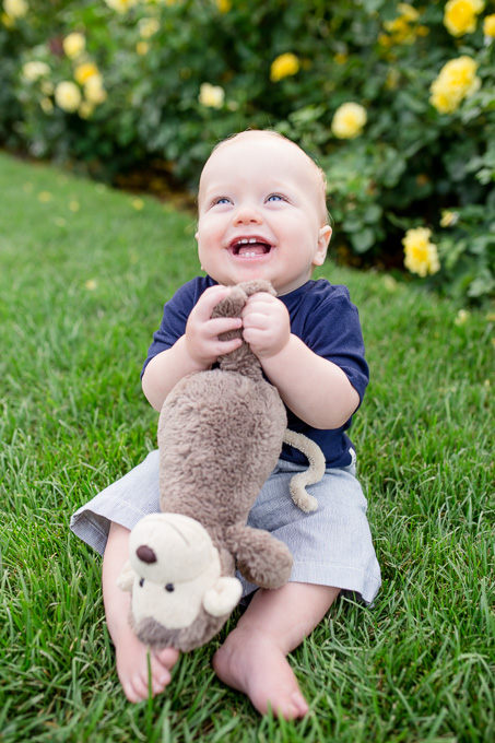 9 month old baby boy chewing on his favorite monkey toy