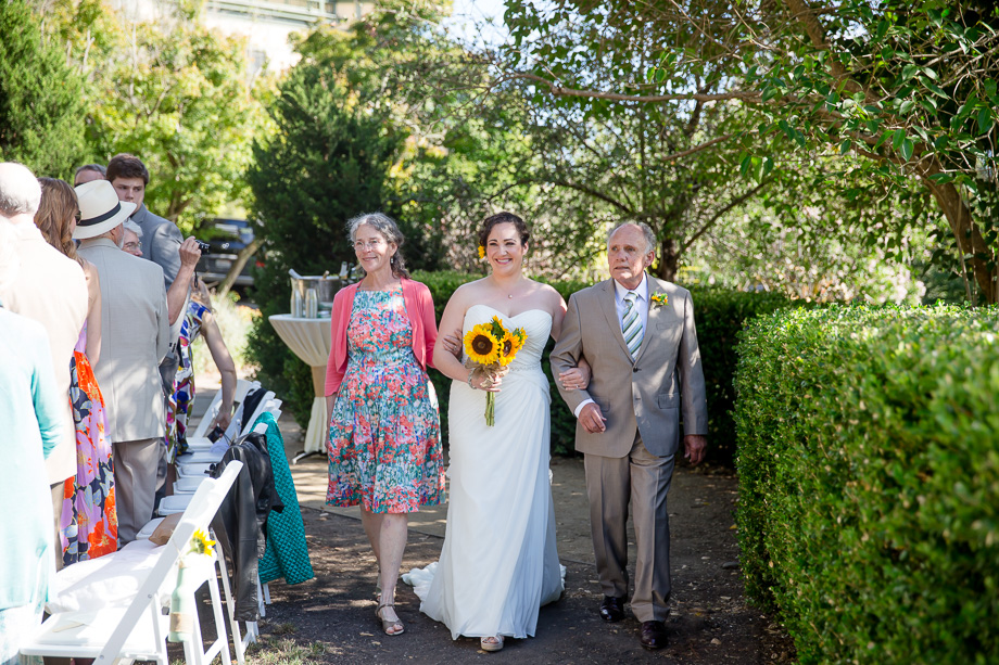 bride walking down the aisle with parents