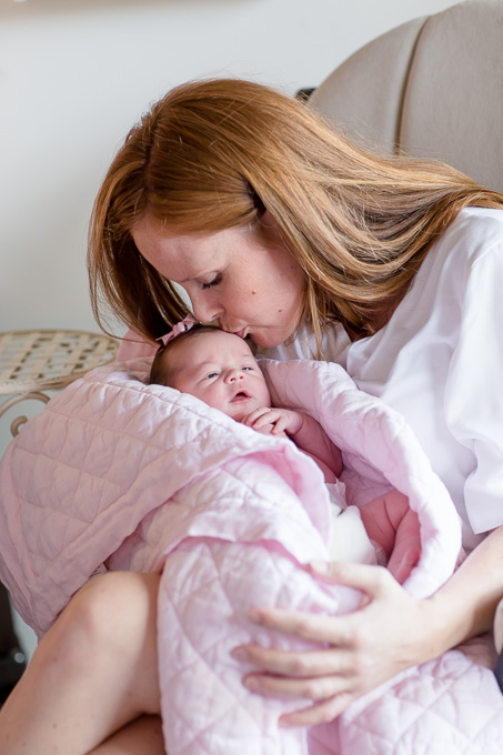 mom giving baby girl a kiss