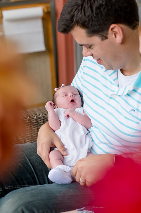 dad and his one week old baby girl in her arm