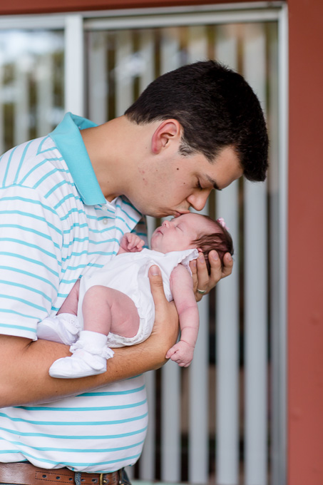 daddy giving newborn girl lots of kisses