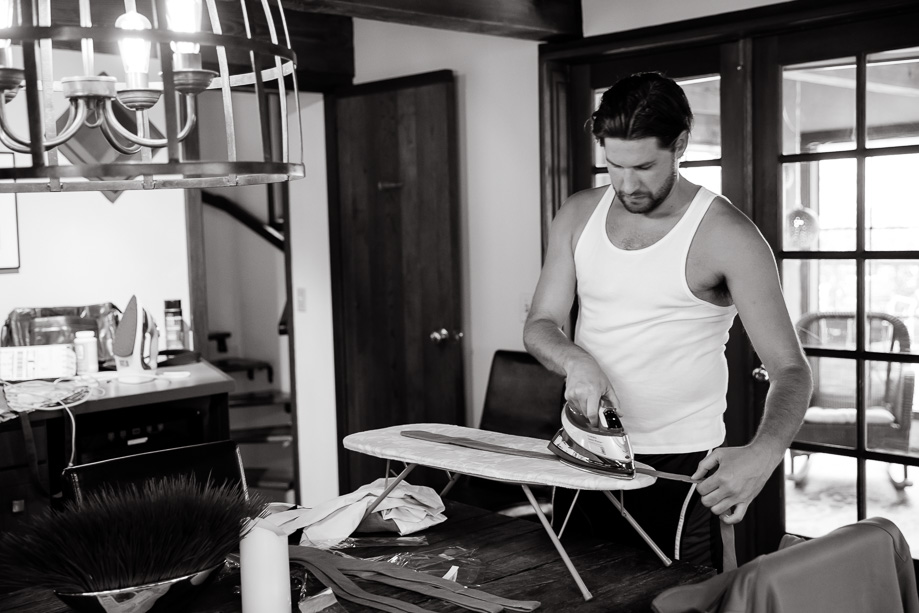 groomsman ironing his wedding tie