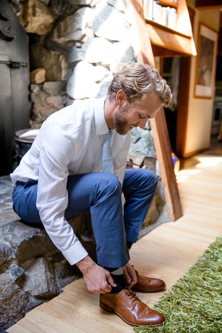 groom putting on his wedding shoes