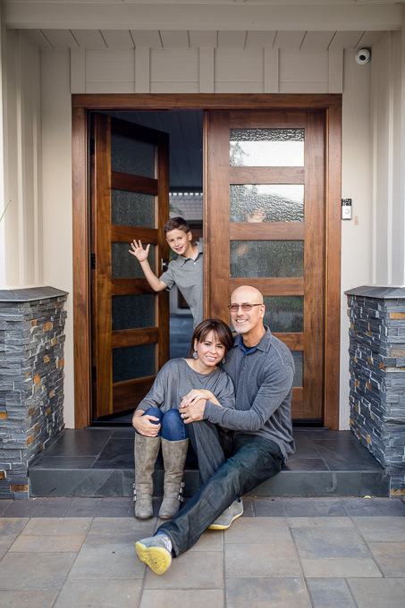 son waving through doorway