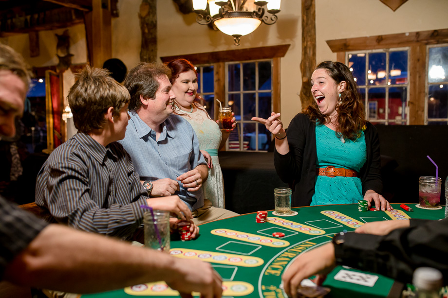 wedding guests having fun at the poker table inside the farm house at long branch saloon, half moon bay