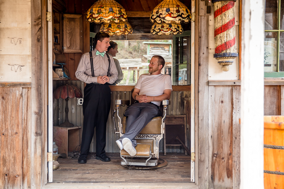 groom and best man chilling in a rustic hair salon before the ceremony