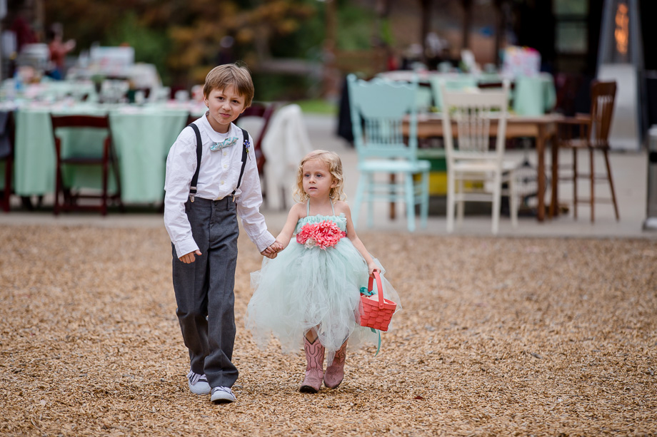 cute ring bearer and flower girl walking down the aisle