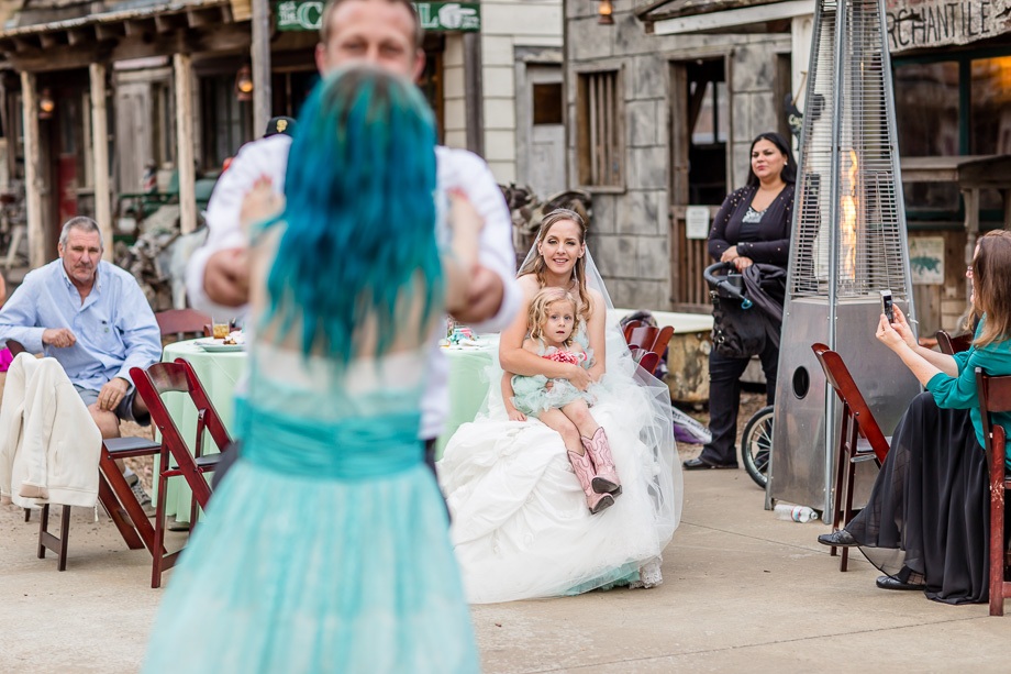 bride watching her husband and daughter dancing