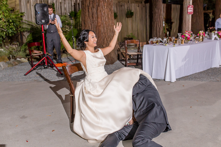 groom fetching the garter from under bride's dress