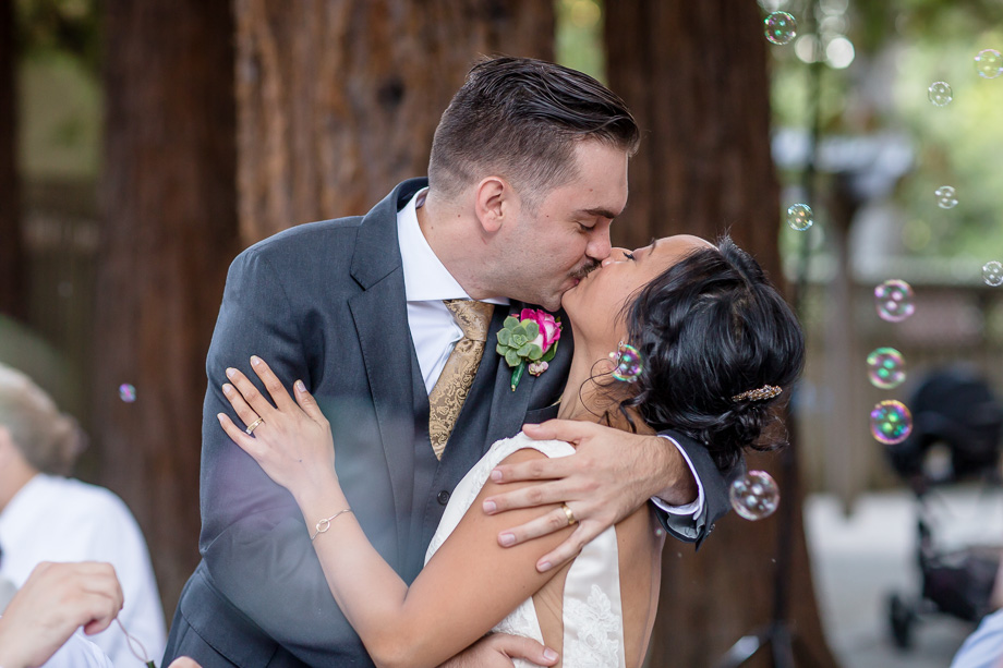 bride and groom kissing surrounded by bubbles