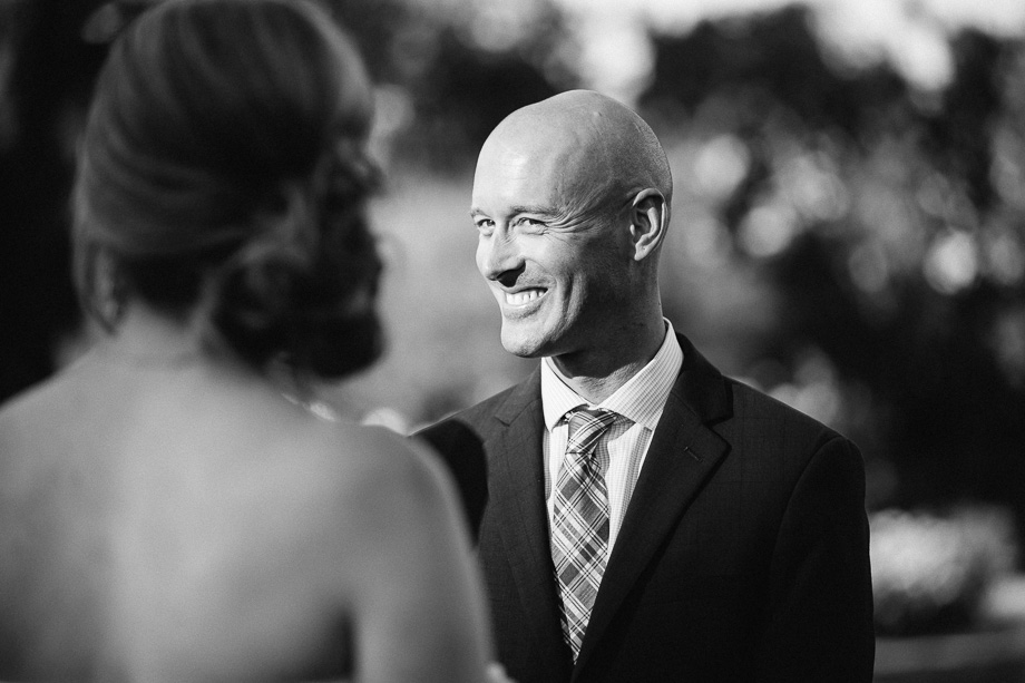 groom smiling at bride during wedding ceremony