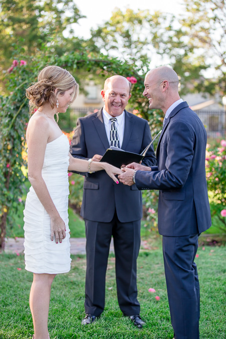groom putting wedding ring on bride's finger