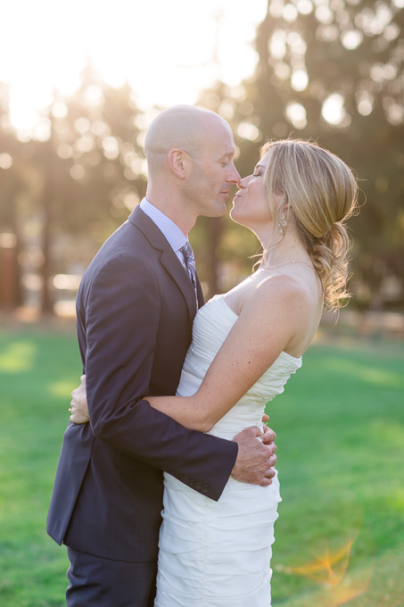 bride and groom kissing under golden sun