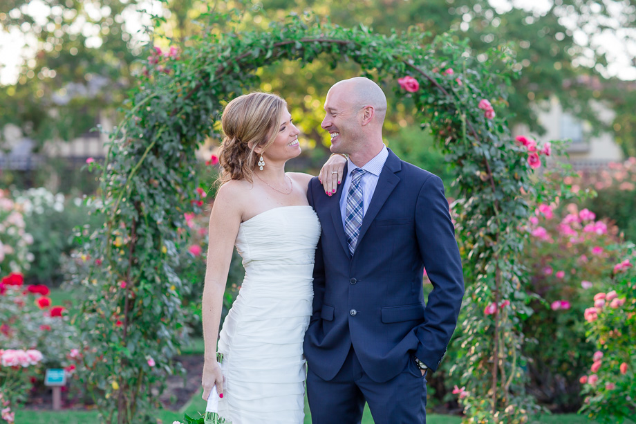 newlyweds standing in front of the arch at san jose rose garden