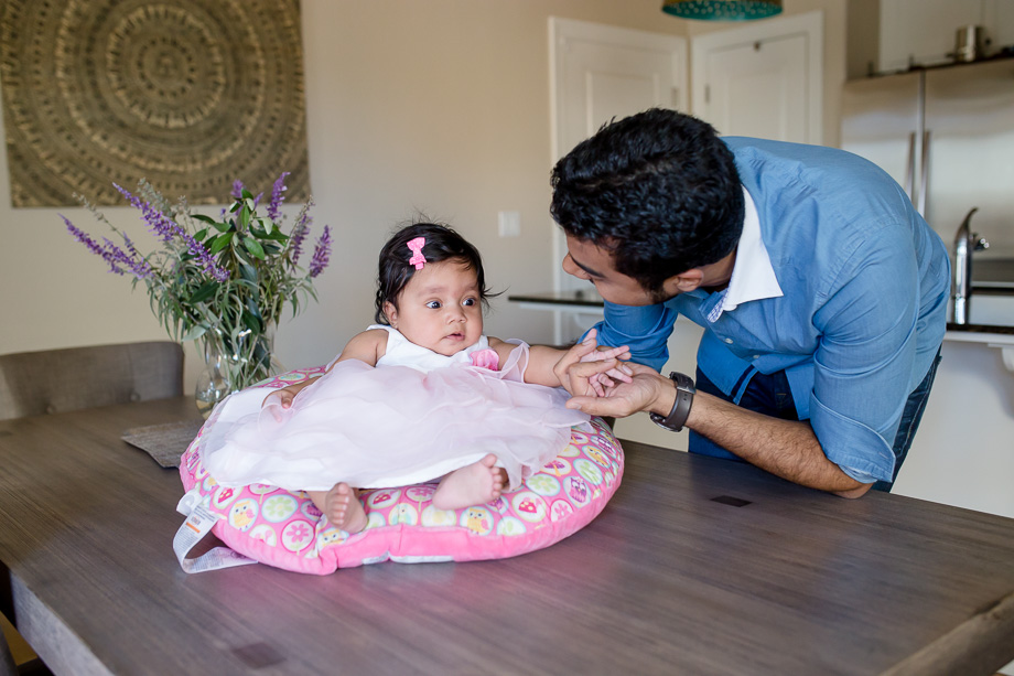six month baby on table looking at daddy