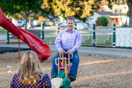 parents with daughter on playgr0ound