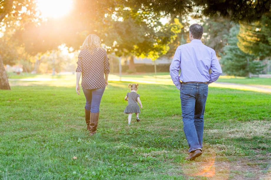 family with daughter walking into the sunset
