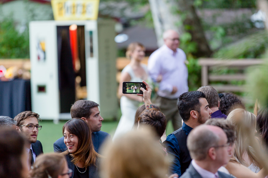 guest taking iPhone photo of bride