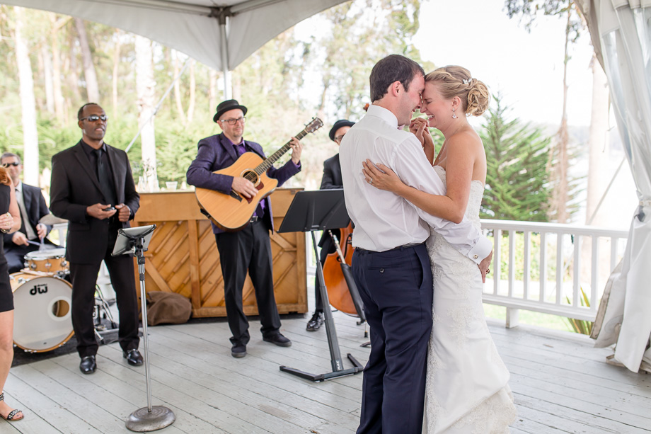 bride laughing really hard during first dance in white tent wedding